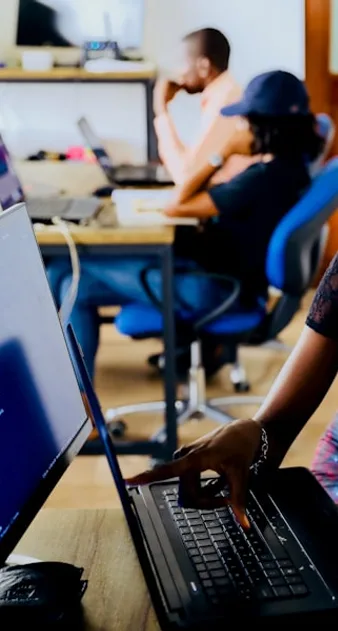 Two people working together at a computer, building an interface.