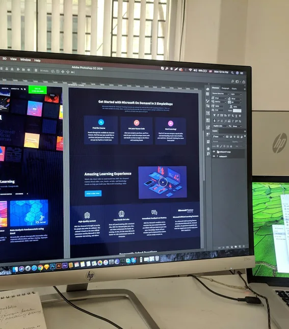 A wide monitor showing a chat assistant open beside a product interface.
